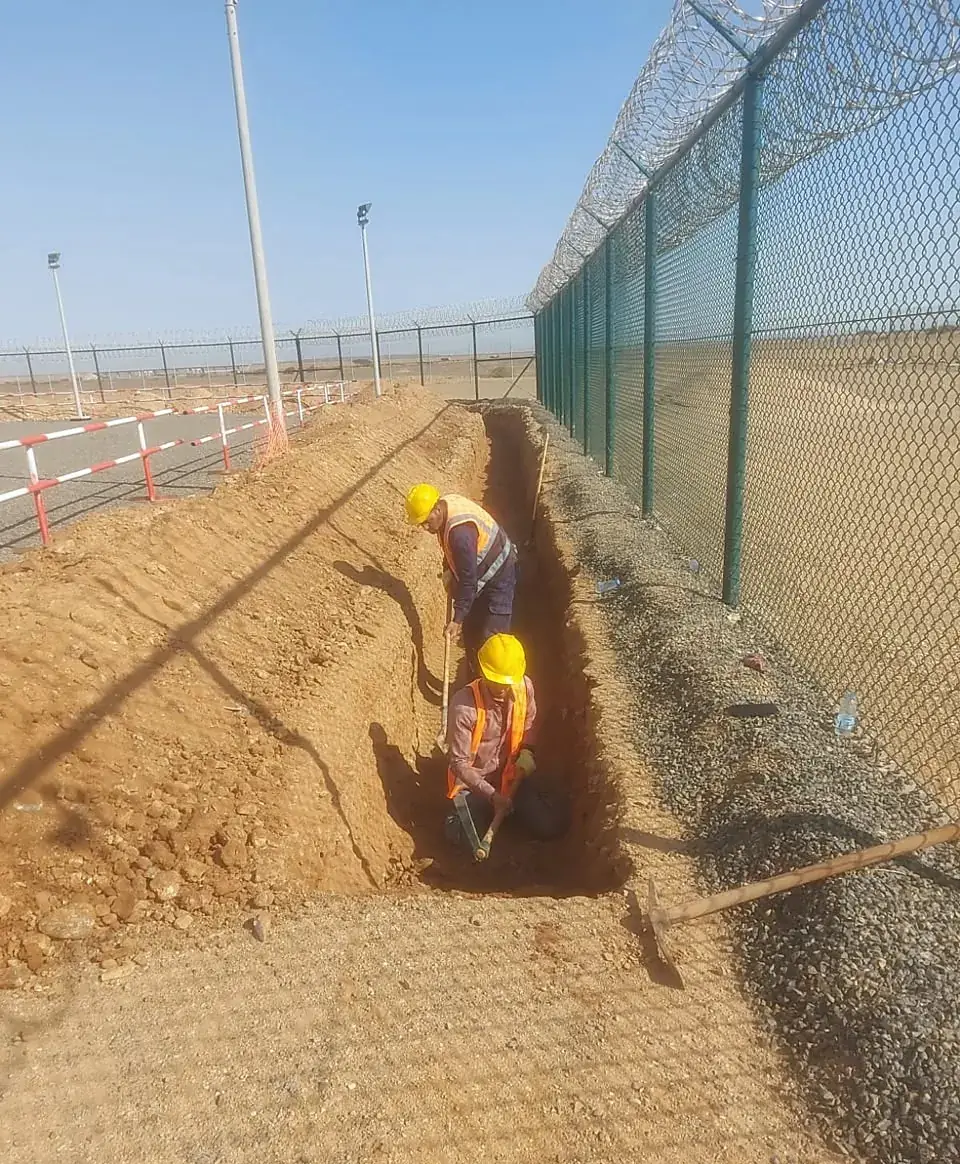 Cable trench beside a security fence at a reservoir