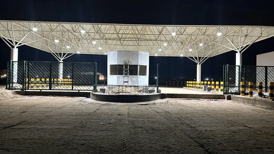 Illuminated security gate canopy at night